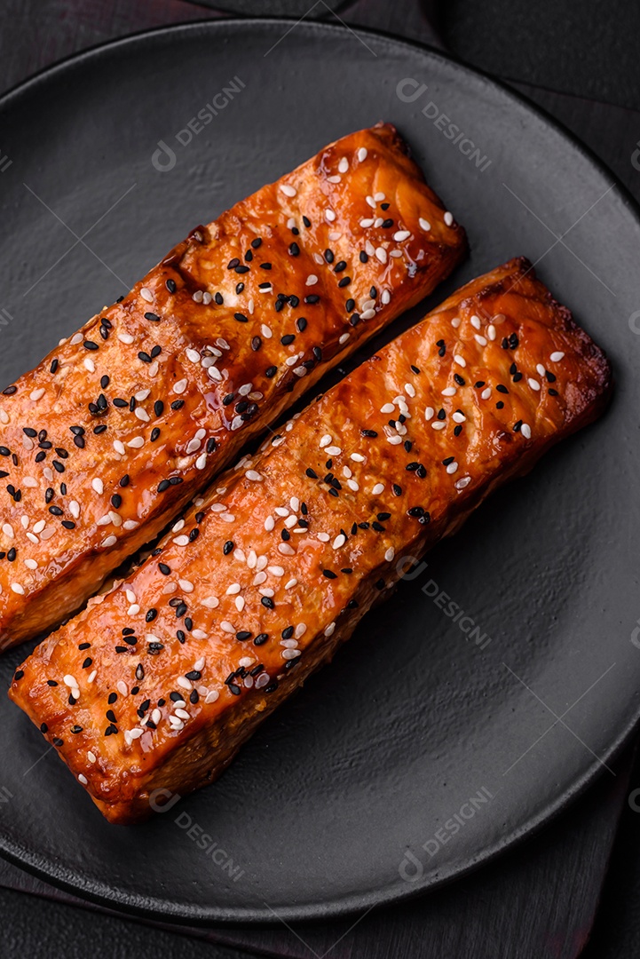 Delicioso peixe vermelho grelhado fresco com sal, especiarias e ervas sobre um fundo escuro de concreto