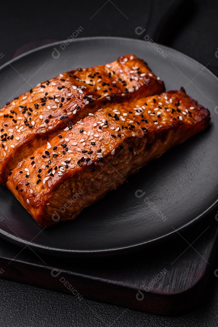 Delicioso peixe vermelho grelhado fresco com sal, especiarias e ervas sobre um fundo escuro de concreto