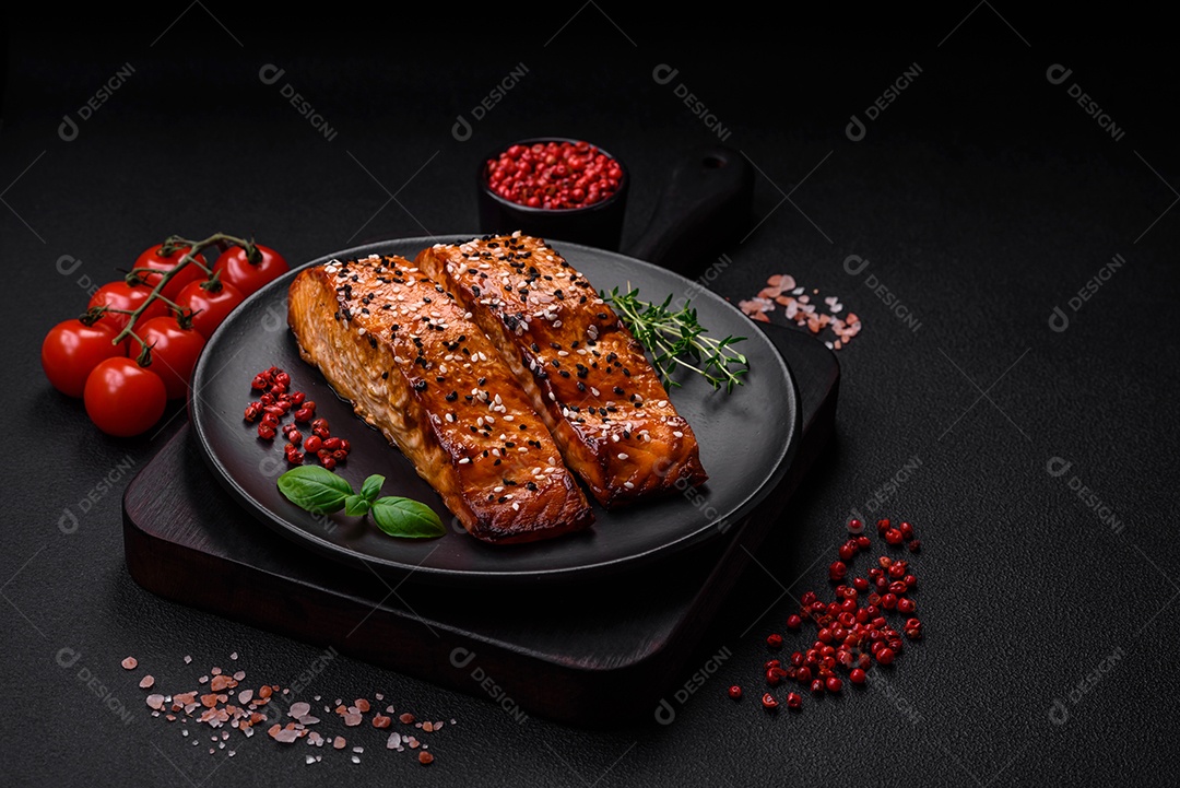 Delicioso peixe vermelho grelhado fresco com sal, especiarias e ervas sobre um fundo escuro de concreto