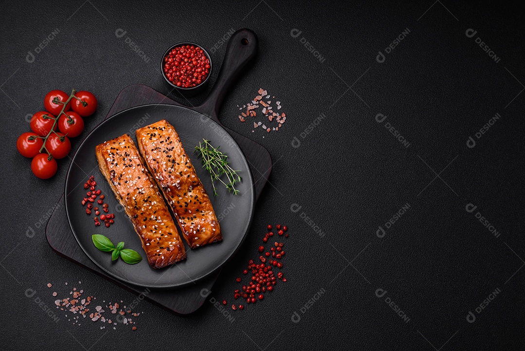 Delicioso peixe vermelho grelhado fresco com sal, especiarias e ervas sobre um fundo escuro de concreto