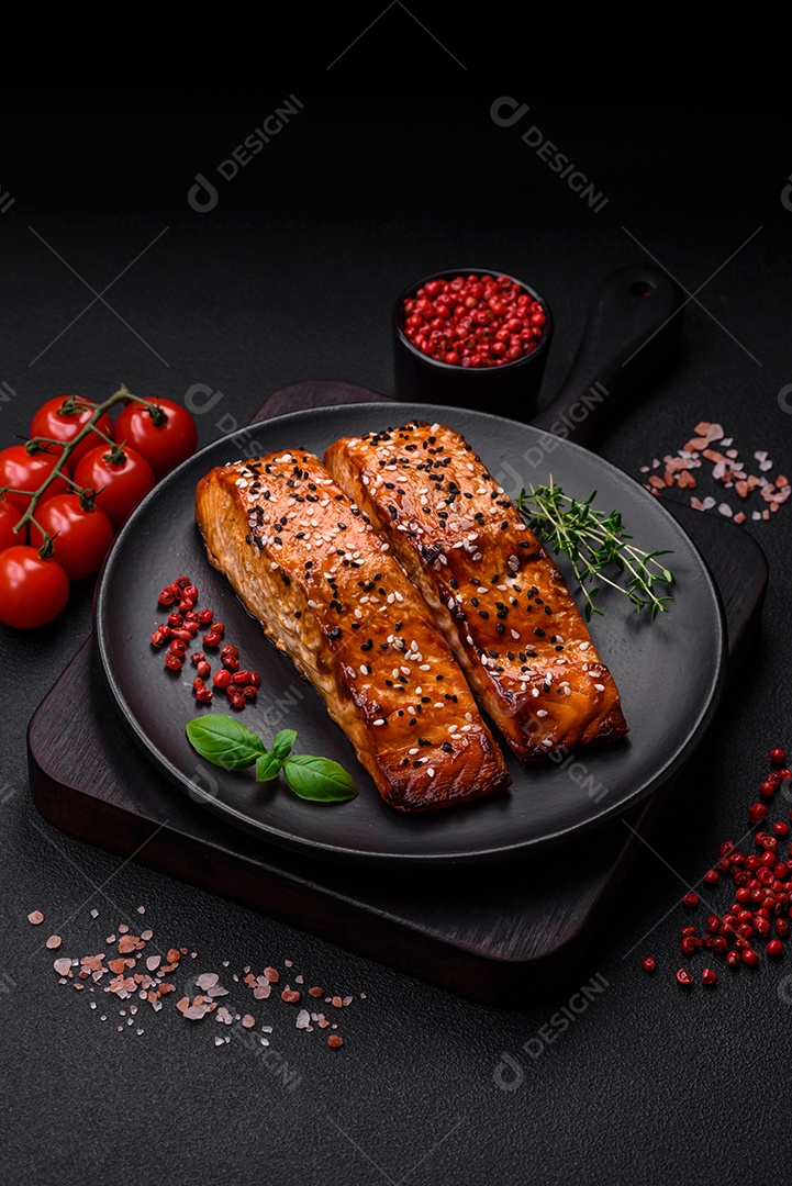 Delicioso peixe vermelho grelhado fresco com sal, especiarias e ervas sobre um fundo escuro de concreto