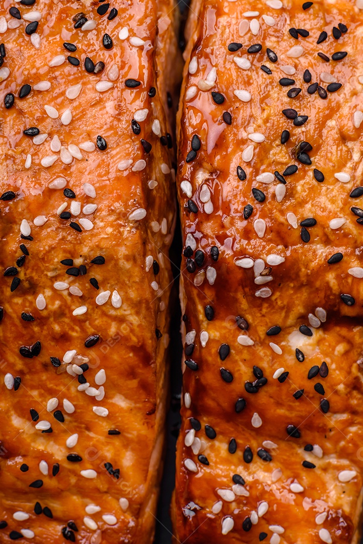 Delicioso peixe vermelho grelhado fresco com sal, especiarias e ervas sobre um fundo escuro de concreto