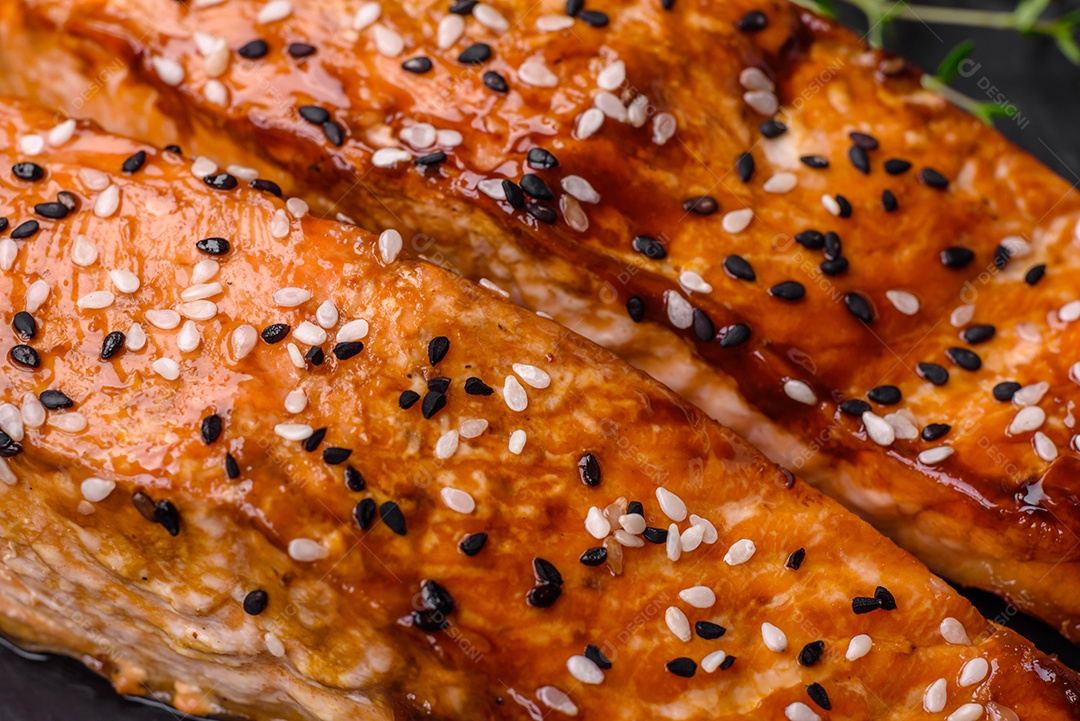 Delicioso peixe vermelho grelhado fresco com sal, especiarias e ervas sobre um fundo escuro de concreto