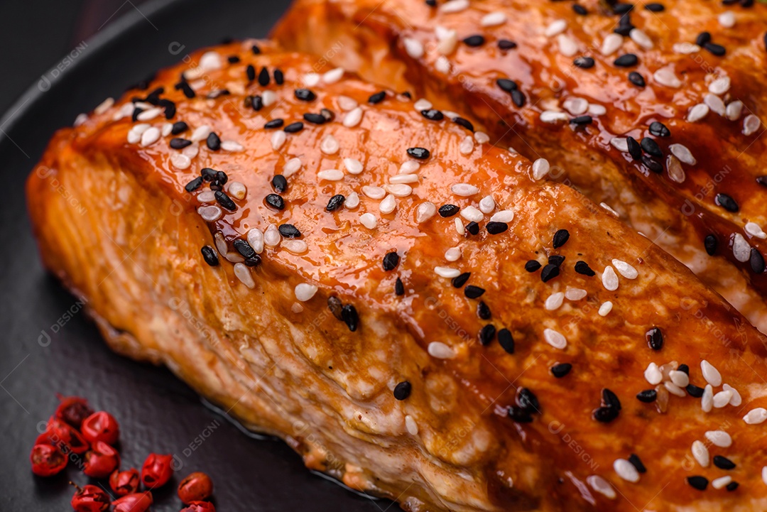 Delicioso peixe vermelho grelhado fresco com sal, especiarias e ervas sobre um fundo escuro de concreto