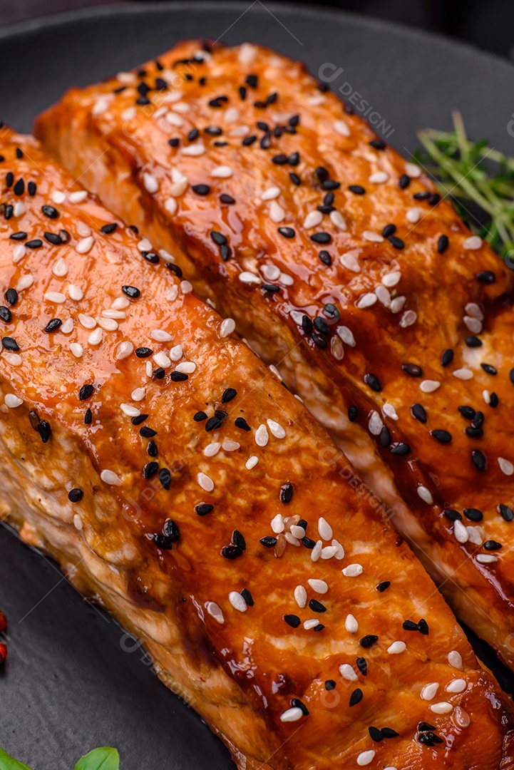 Delicioso peixe vermelho grelhado fresco com sal, especiarias e ervas sobre um fundo escuro de concreto