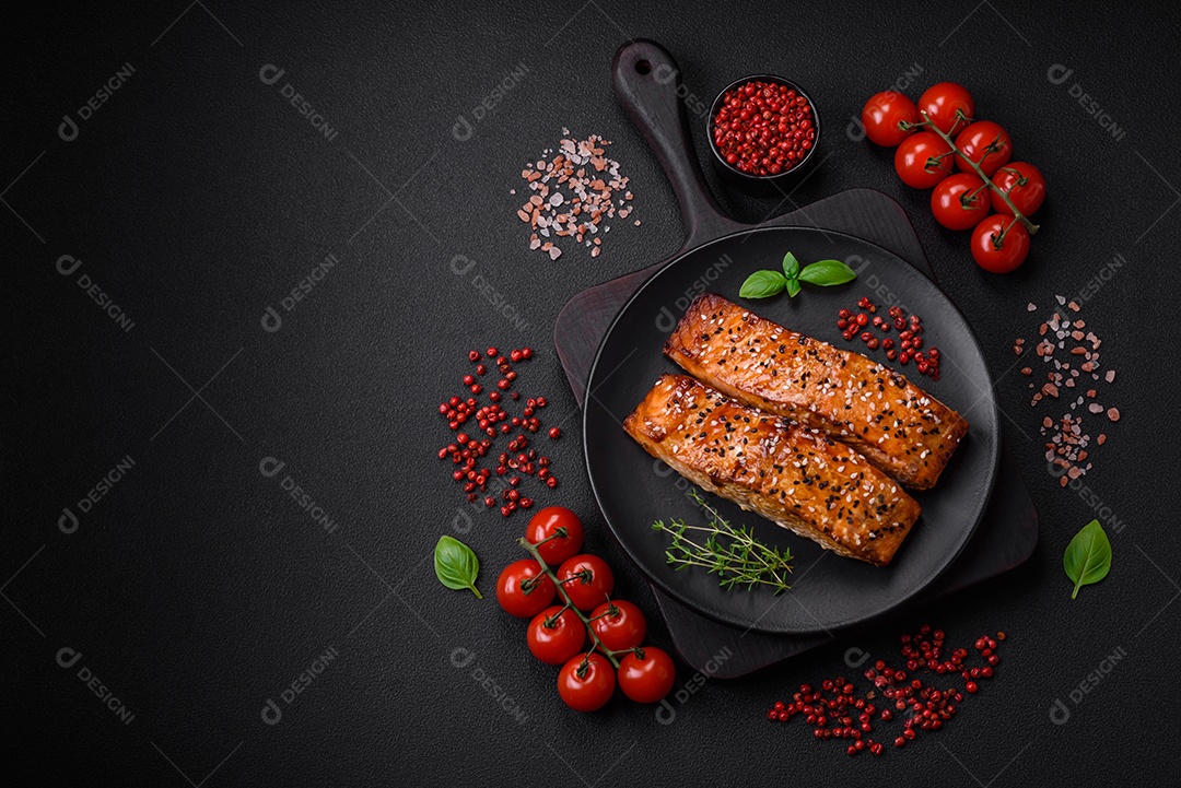 Delicioso peixe vermelho grelhado fresco com sal, especiarias e ervas sobre um fundo escuro de concreto