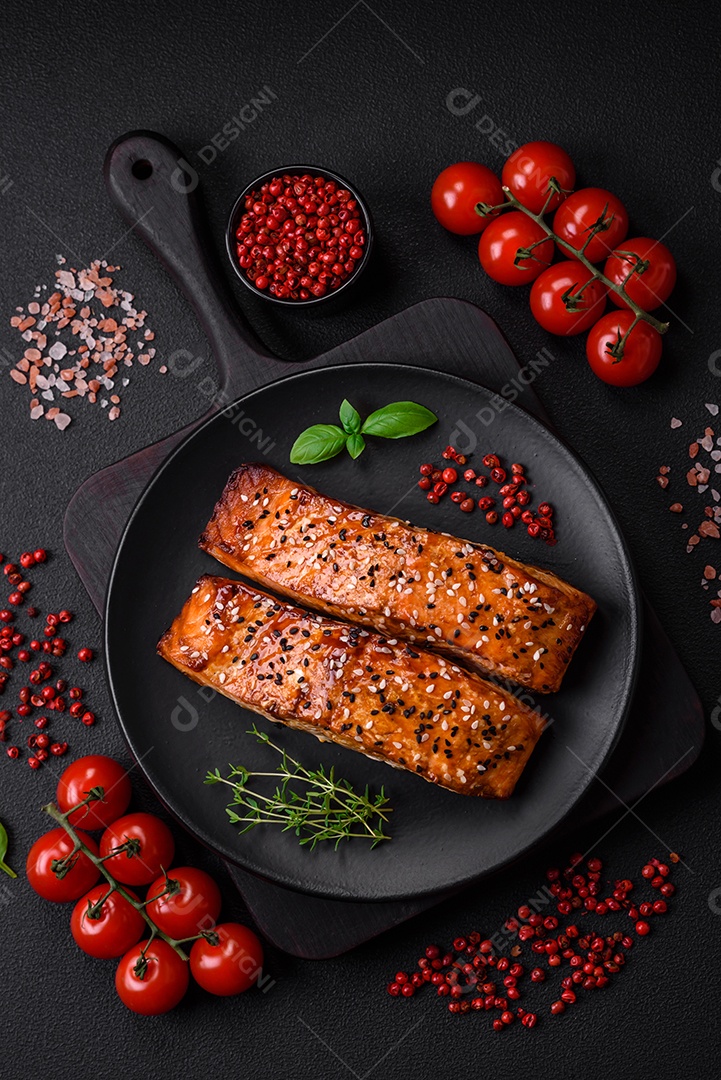 Delicioso peixe vermelho grelhado fresco com sal, especiarias e ervas sobre um fundo escuro de concreto