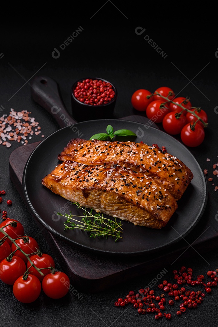 Delicioso peixe vermelho grelhado fresco com sal, especiarias e ervas sobre um fundo escuro de concreto