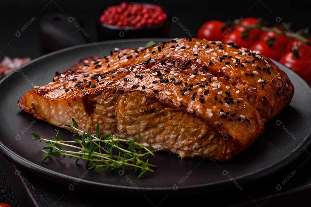 Delicioso peixe vermelho grelhado fresco com sal, especiarias e ervas sobre um fundo escuro de concreto