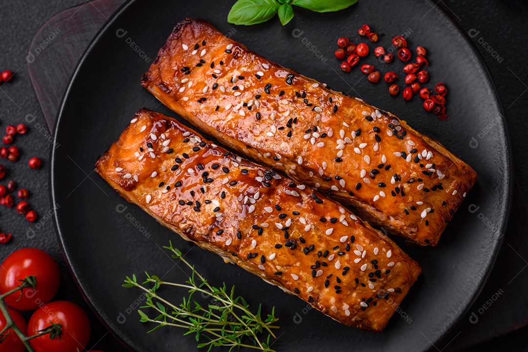 Delicioso peixe vermelho grelhado fresco com sal, especiarias e ervas sobre um fundo escuro de concreto