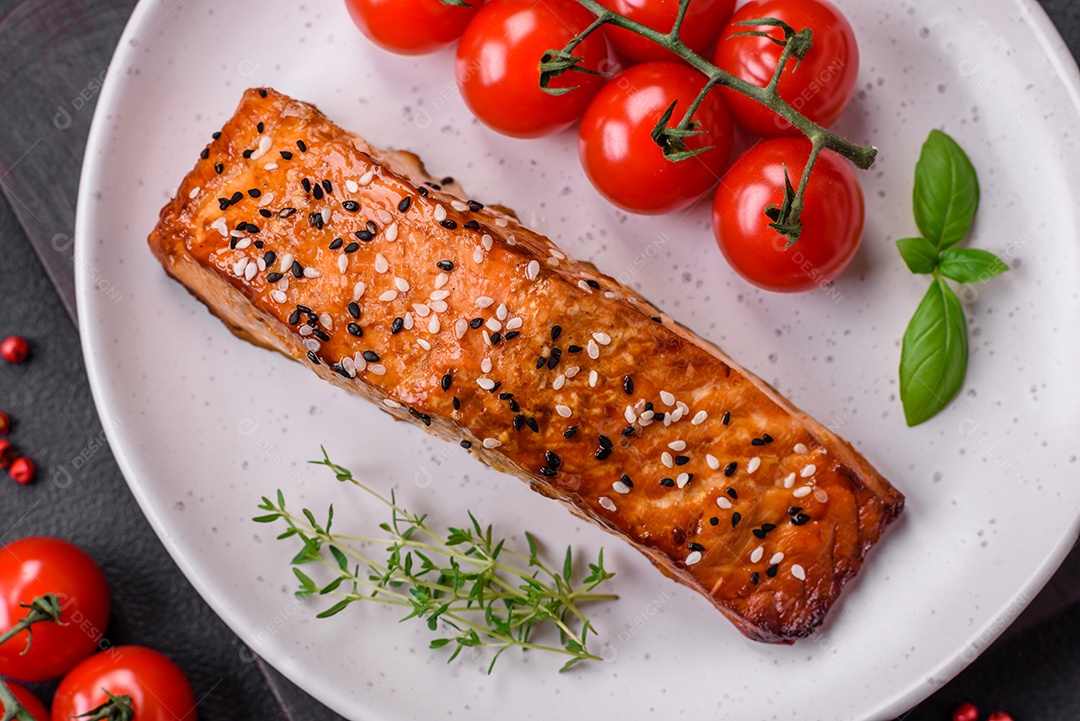 Delicioso peixe vermelho grelhado fresco com sal, especiarias e ervas sobre um fundo escuro de concreto