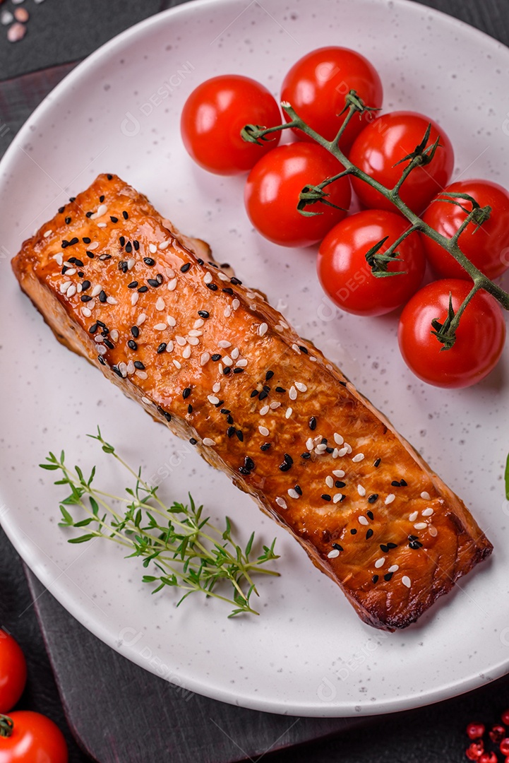 Delicioso peixe vermelho grelhado fresco com sal, especiarias e ervas sobre um fundo escuro de concreto