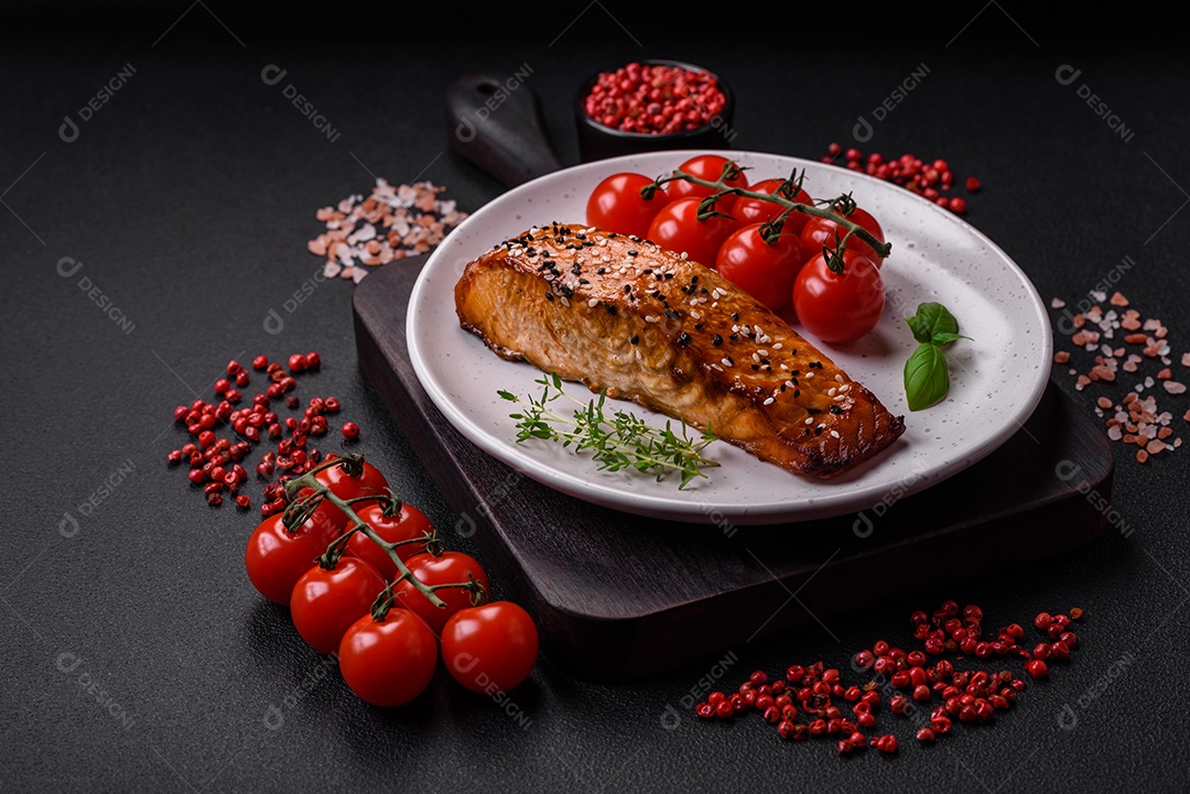 Delicioso peixe vermelho grelhado fresco com sal, especiarias e ervas sobre um fundo escuro de concreto