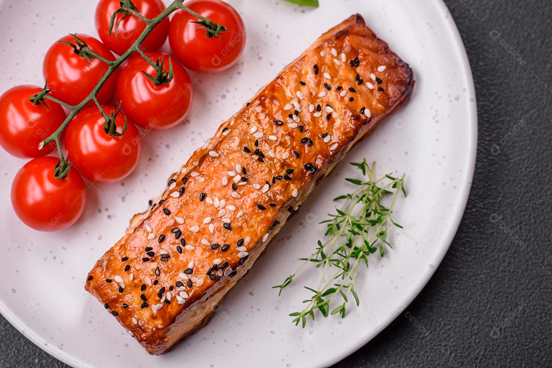 Delicioso peixe vermelho grelhado fresco com sal, especiarias e ervas sobre um fundo escuro de concreto