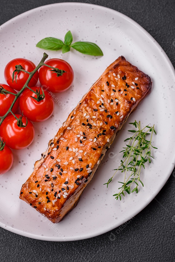 Delicioso peixe vermelho grelhado fresco com sal, especiarias e ervas sobre um fundo escuro de concreto