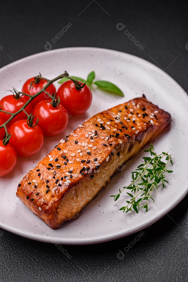 Delicioso peixe vermelho grelhado fresco com sal, especiarias e ervas sobre um fundo escuro de concreto