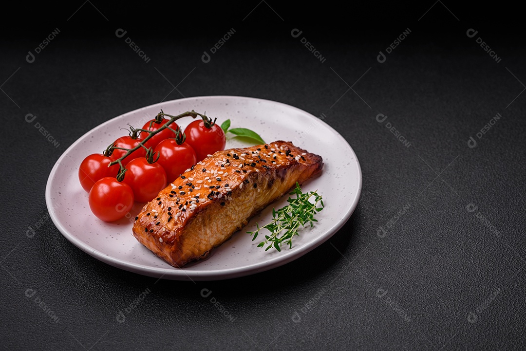 Delicioso peixe vermelho grelhado fresco com sal, especiarias e ervas sobre um fundo escuro de concreto