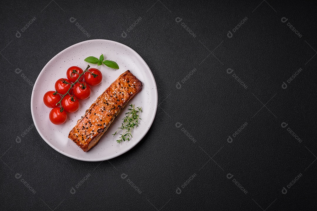 Delicioso peixe vermelho grelhado fresco com sal, especiarias e ervas sobre um fundo escuro de concreto