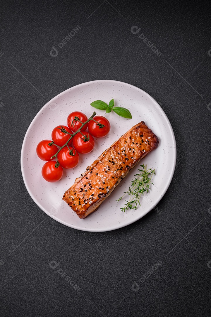 Delicioso peixe vermelho grelhado fresco com sal, especiarias e ervas sobre um fundo escuro de concreto