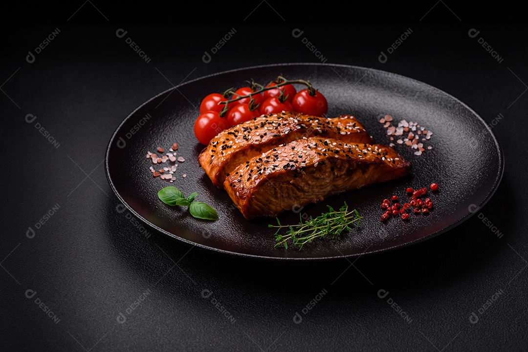 Delicioso peixe vermelho grelhado fresco com sal, especiarias e ervas sobre um fundo escuro de concreto