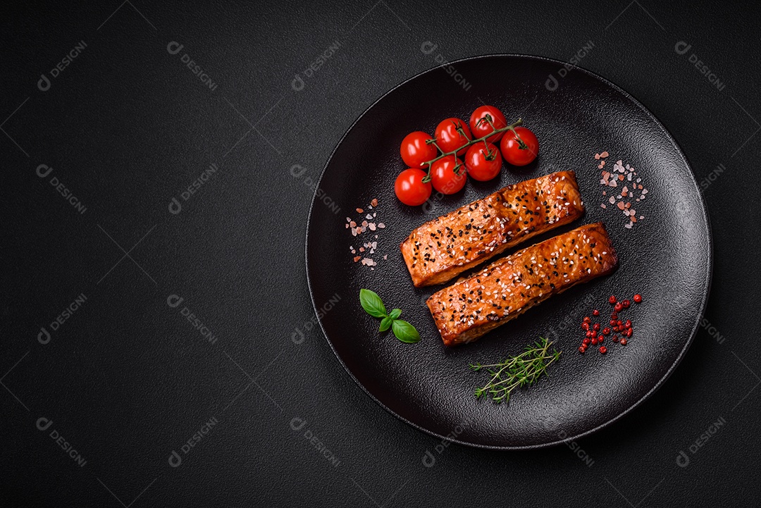 Delicioso peixe vermelho grelhado fresco com sal, especiarias e ervas sobre um fundo escuro de concreto