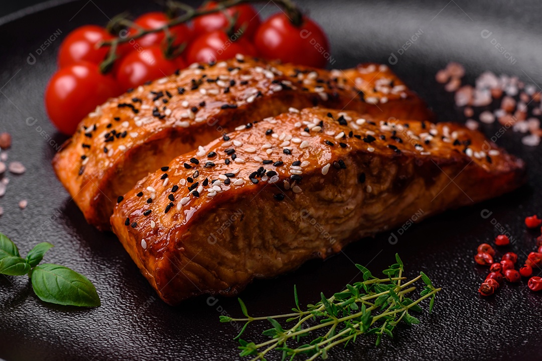 Delicioso peixe vermelho grelhado fresco com sal, especiarias e ervas sobre um fundo escuro de concreto