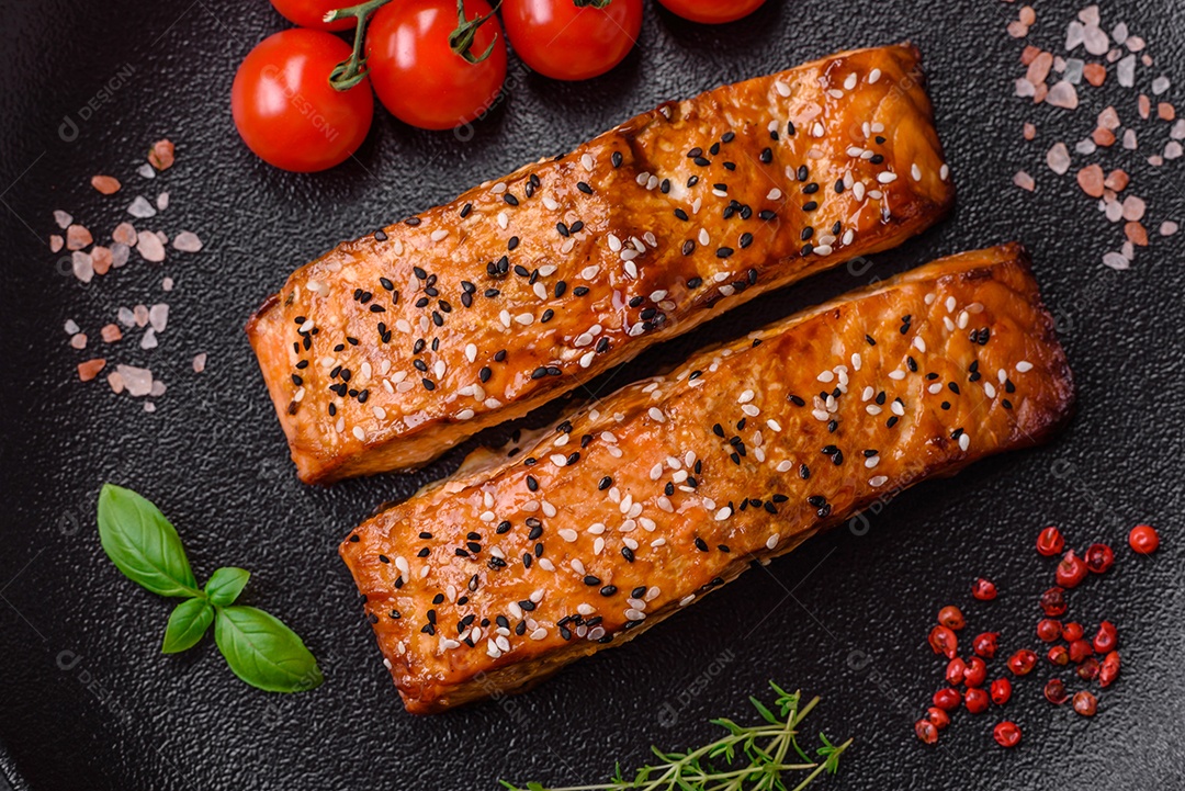 Delicioso peixe vermelho grelhado fresco com sal, especiarias e ervas sobre um fundo escuro de concreto