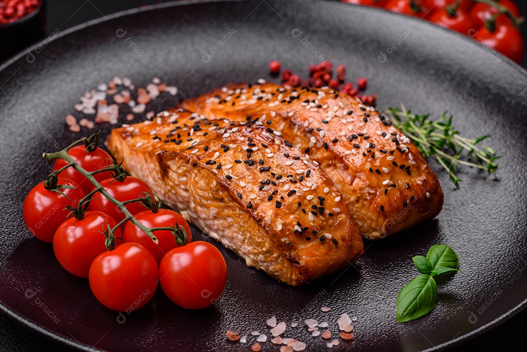 Delicioso peixe vermelho grelhado fresco com sal, especiarias e ervas sobre um fundo escuro de concreto