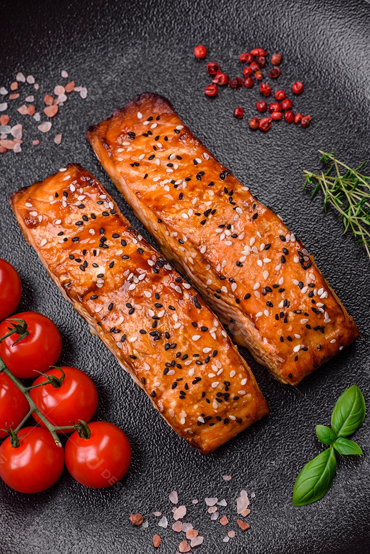 Delicioso peixe vermelho grelhado fresco com sal, especiarias e ervas sobre um fundo escuro de concreto
