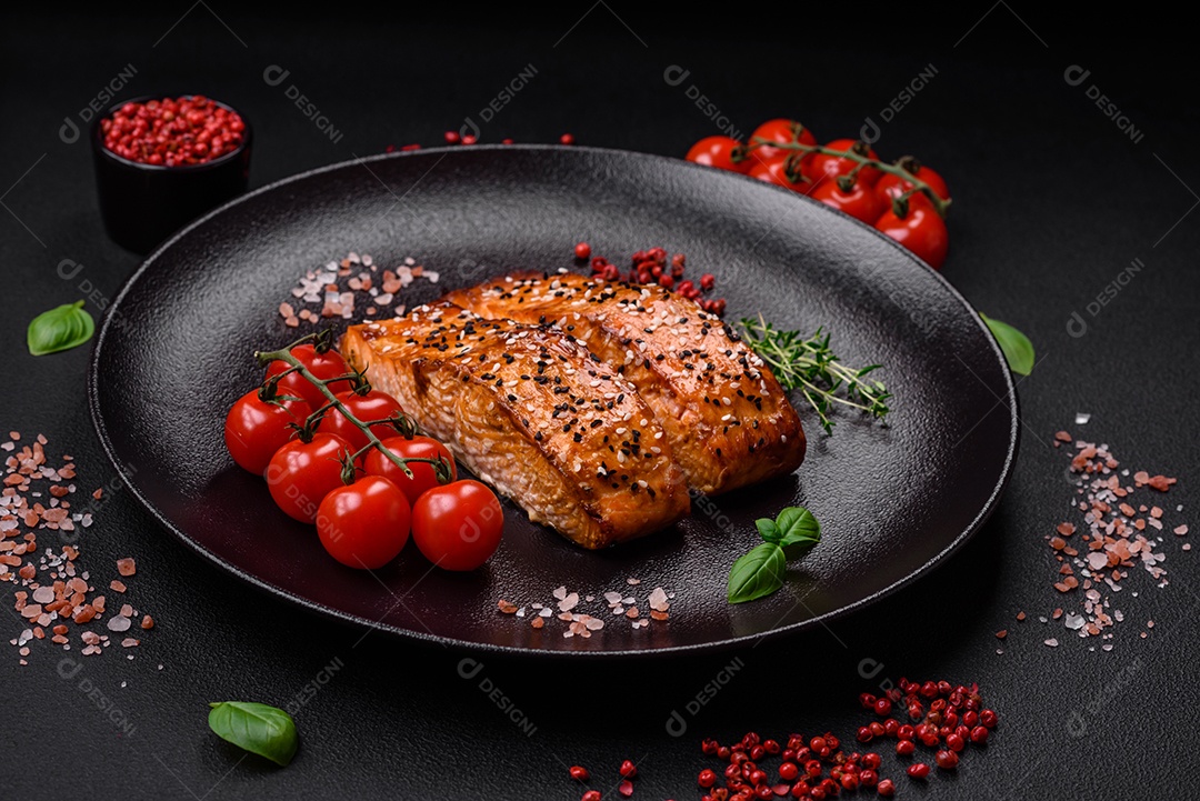 Delicioso peixe vermelho grelhado fresco com sal, especiarias e ervas sobre um fundo escuro de concreto