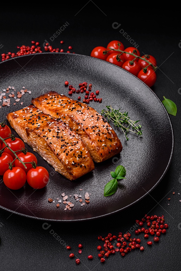 Delicioso peixe vermelho grelhado fresco com sal, especiarias e ervas sobre um fundo escuro de concreto