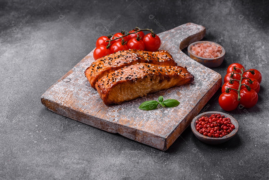 Delicioso peixe vermelho grelhado fresco com sal, especiarias e ervas sobre um fundo escuro de concreto