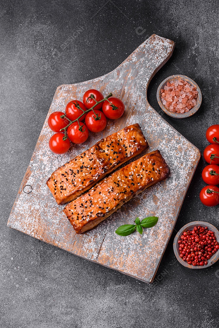 Delicioso peixe vermelho grelhado fresco com sal, especiarias e ervas sobre um fundo escuro de concreto