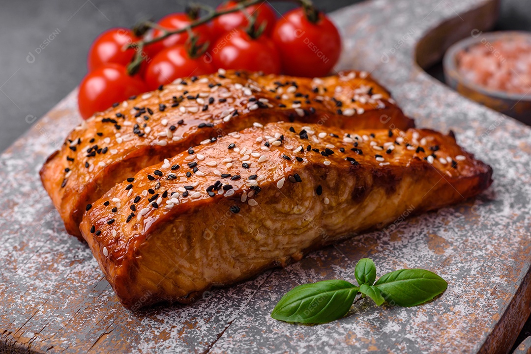 Delicioso peixe vermelho grelhado fresco com sal, especiarias e ervas sobre um fundo escuro de concreto