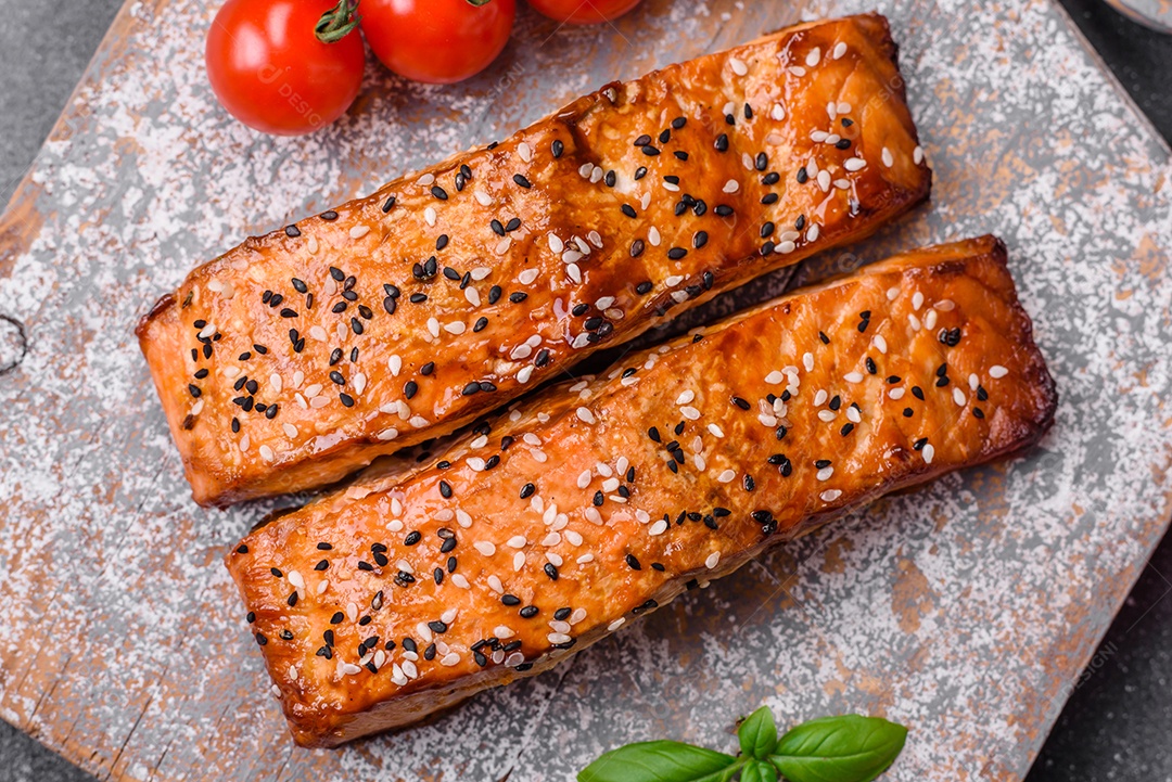 Delicioso peixe vermelho grelhado fresco com sal, especiarias e ervas sobre um fundo escuro de concreto