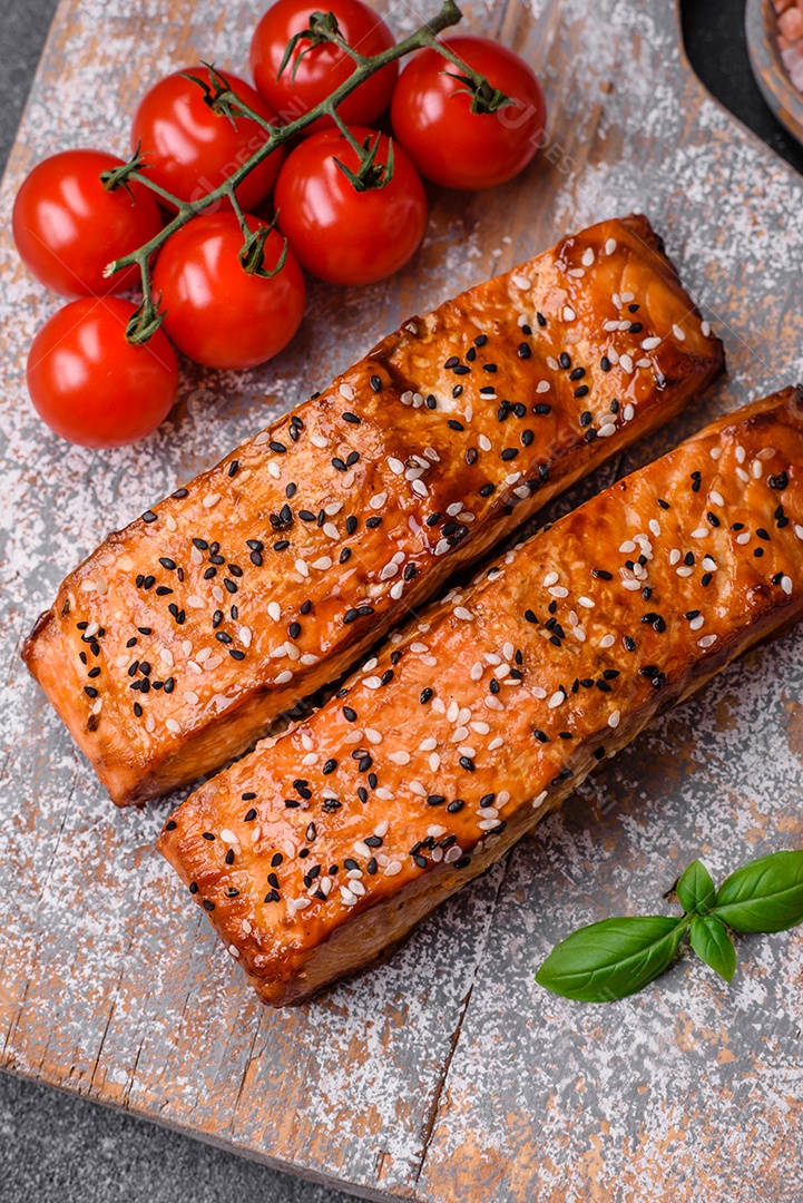 Delicioso peixe vermelho grelhado fresco com sal, especiarias e ervas sobre um fundo escuro de concreto