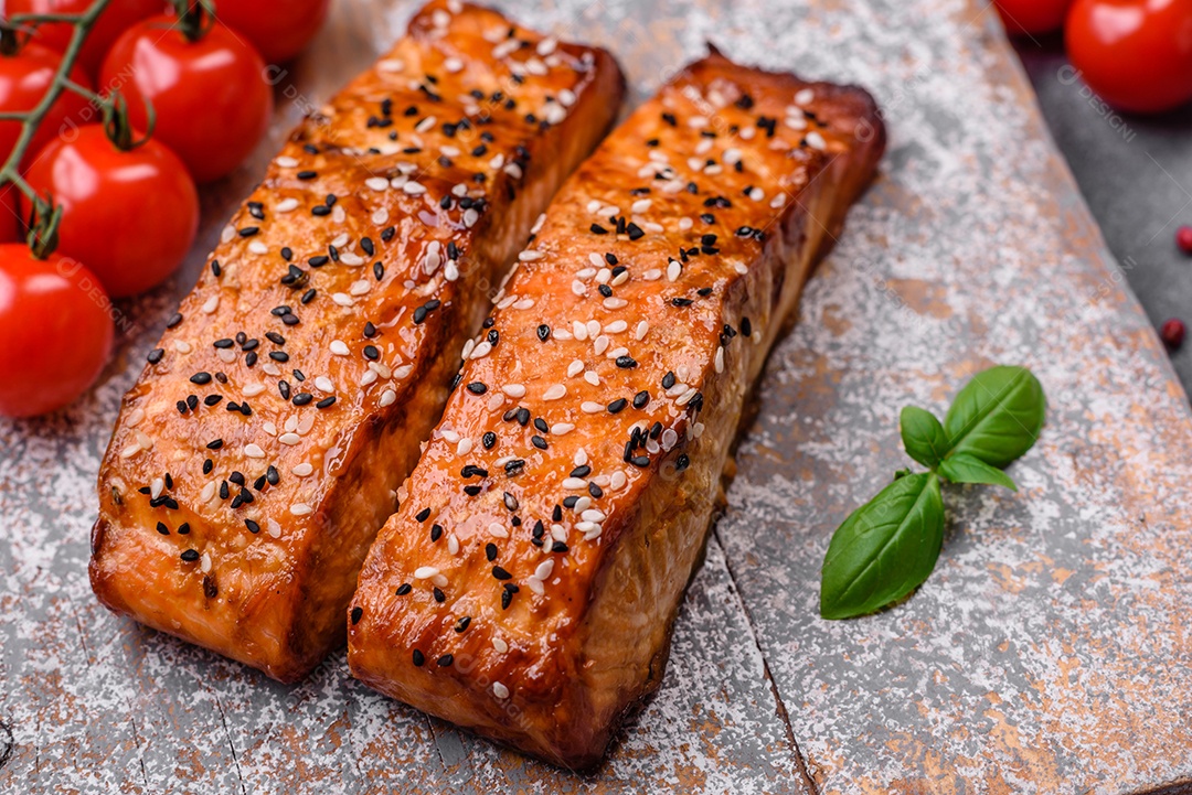 Delicioso peixe vermelho grelhado fresco com sal, especiarias e ervas sobre um fundo escuro de concreto