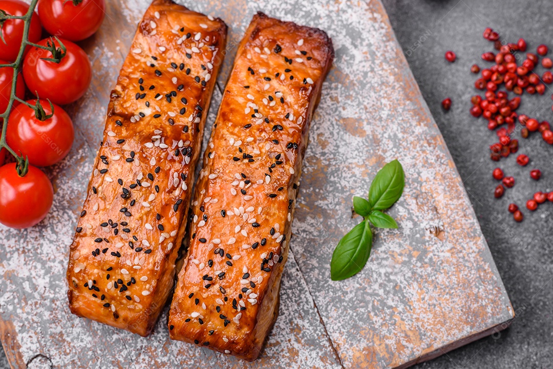 Delicioso peixe vermelho grelhado fresco com sal, especiarias e ervas sobre um fundo escuro de concreto