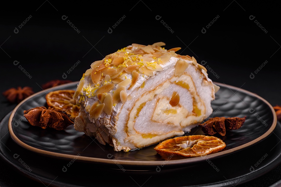Rolo de merengue delicioso, fresco e doce com creme, lascas de amêndoa, nozes e frutas cortadas em fatias sobre um fundo escuro de concreto