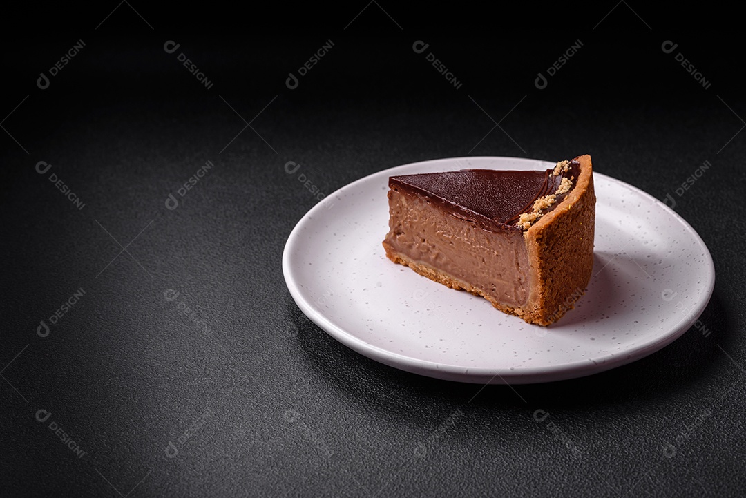 Rolo de merengue delicioso, fresco e doce com creme, lascas de amêndoa, nozes e frutas cortadas em fatias sobre um fundo escuro de concreto