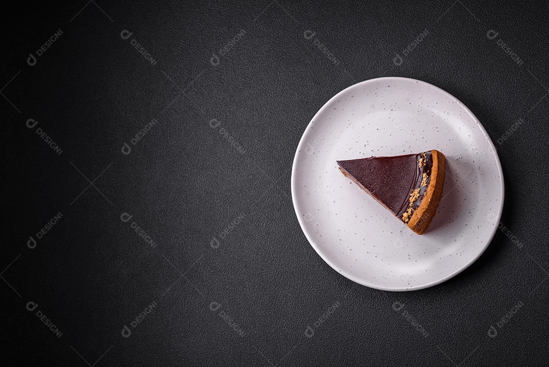 Rolo de merengue delicioso, fresco e doce com creme, lascas de amêndoa, nozes e frutas cortadas em fatias sobre um fundo escuro de concreto