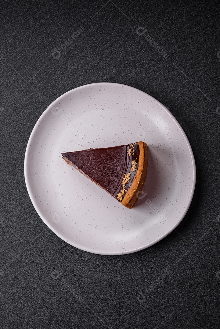 Rolo de merengue delicioso, fresco e doce com creme, lascas de amêndoa, nozes e frutas cortadas em fatias sobre um fundo escuro de concreto