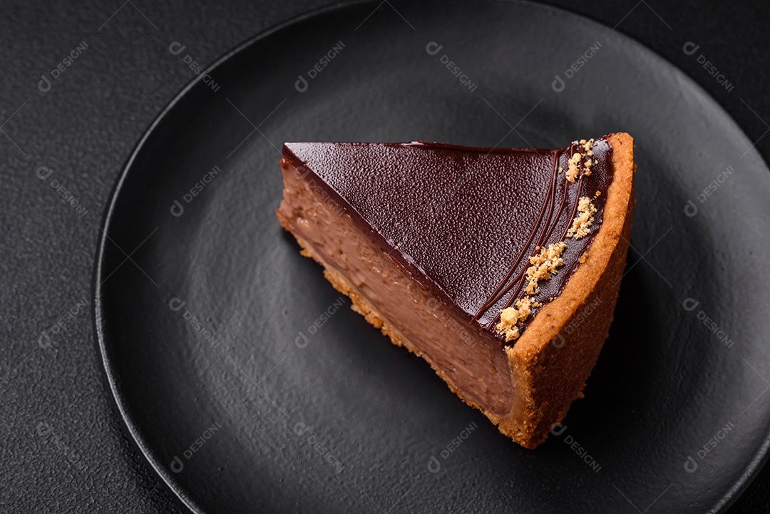 Rolo de merengue delicioso, fresco e doce com creme, lascas de amêndoa, nozes e frutas cortadas em fatias sobre um fundo escuro de concreto