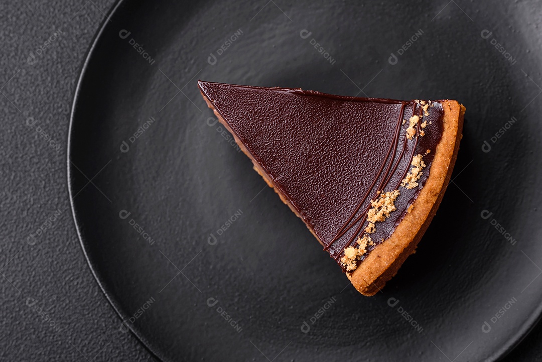 Rolo de merengue delicioso, fresco e doce com creme, lascas de amêndoa, nozes e frutas cortadas em fatias sobre um fundo escuro de concreto