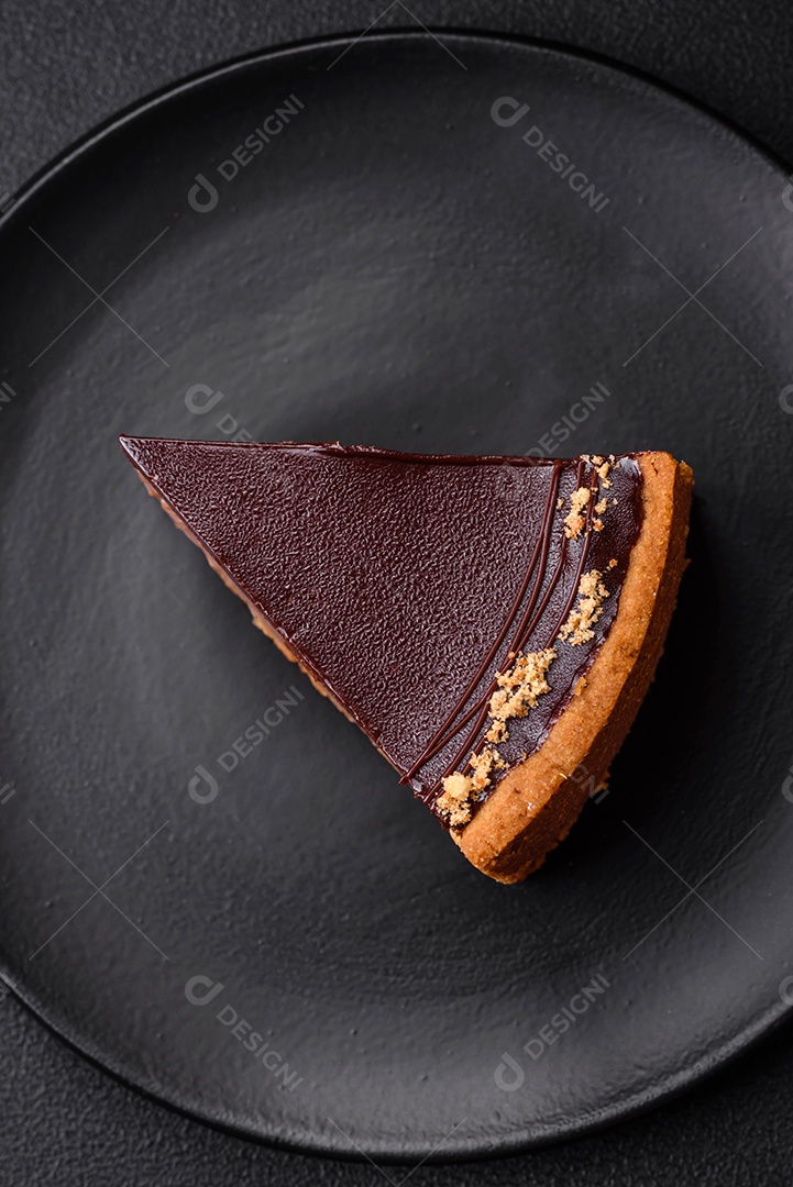 Rolo de merengue delicioso, fresco e doce com creme, lascas de amêndoa, nozes e frutas cortadas em fatias sobre um fundo escuro de concreto