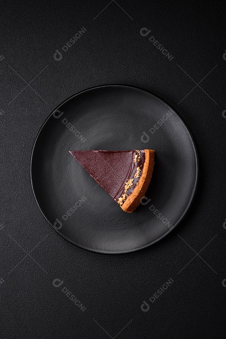 Rolo de merengue delicioso, fresco e doce com creme, lascas de amêndoa, nozes e frutas cortadas em fatias sobre um fundo escuro de concreto