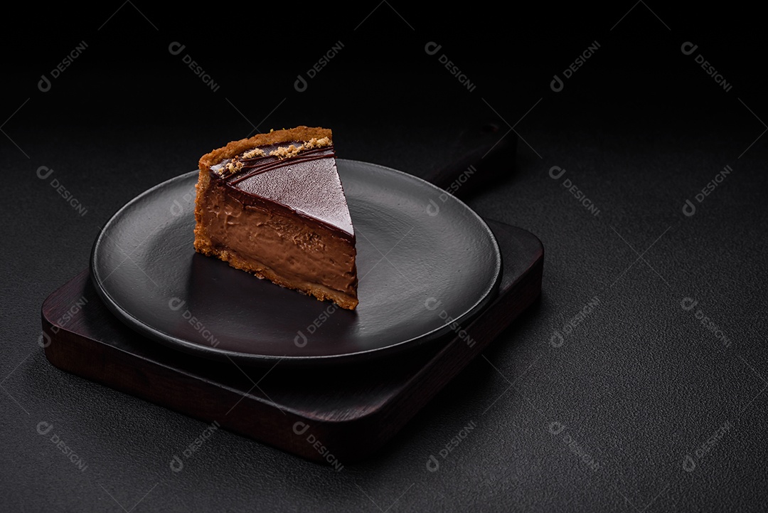 Rolo de merengue delicioso, fresco e doce com creme, lascas de amêndoa, nozes e frutas cortadas em fatias sobre um fundo escuro de concreto