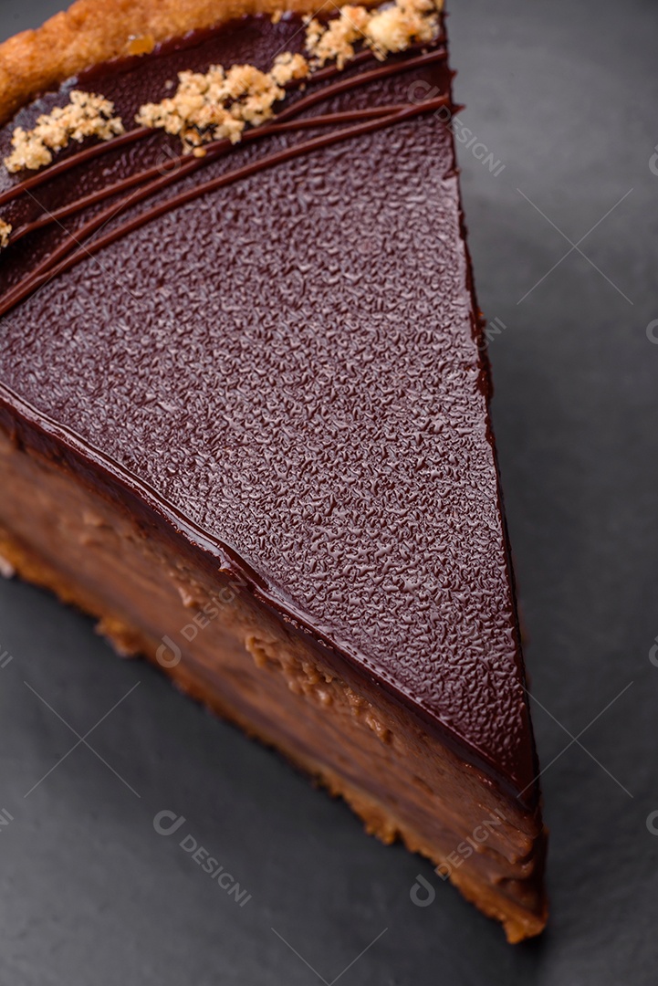 Rolo de merengue delicioso, fresco e doce com creme, lascas de amêndoa, nozes e frutas cortadas em fatias sobre um fundo escuro de concreto