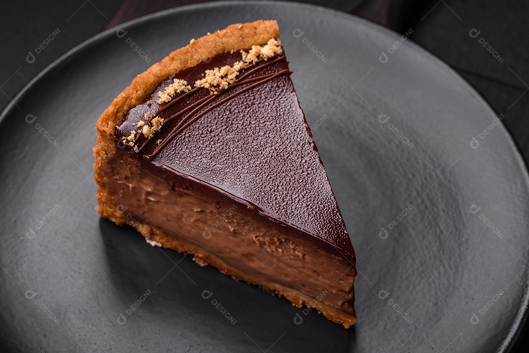 Rolo de merengue delicioso, fresco e doce com creme, lascas de amêndoa, nozes e frutas cortadas em fatias sobre um fundo escuro de concreto