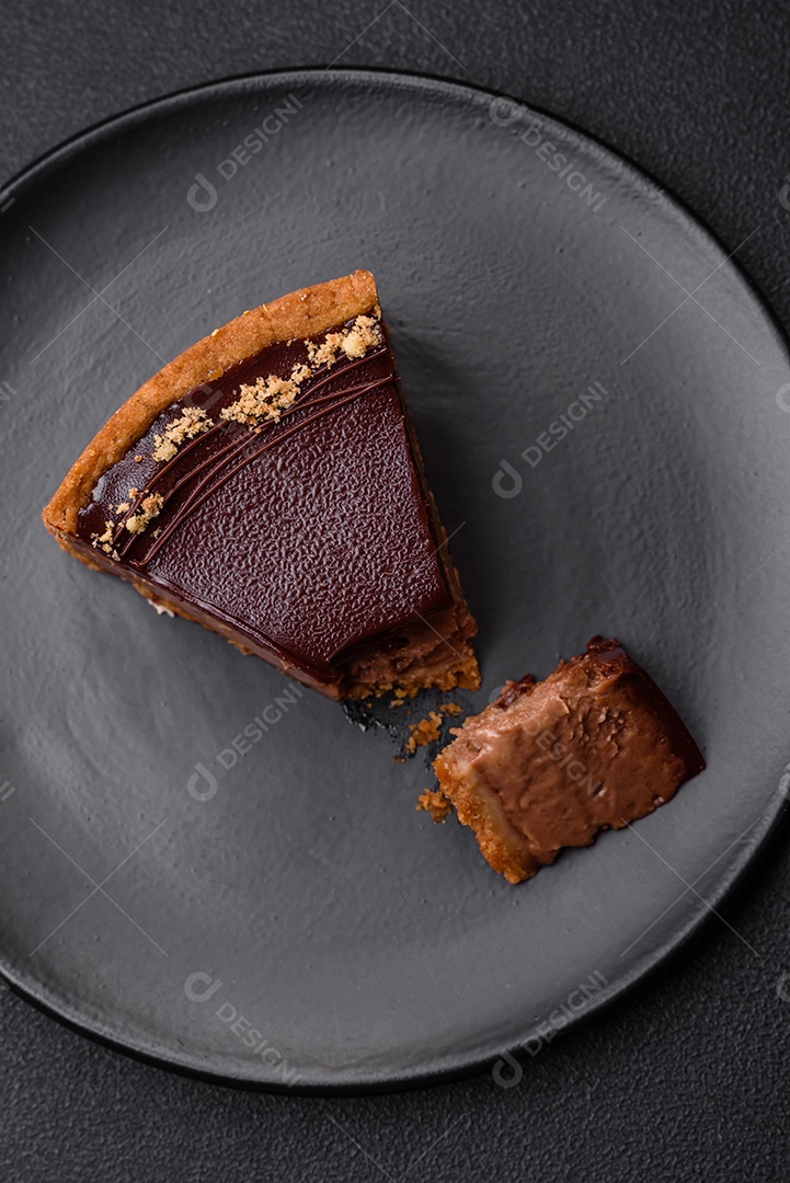 Rolo de merengue delicioso, fresco e doce com creme, lascas de amêndoa, nozes e frutas cortadas em fatias sobre um fundo escuro de concreto